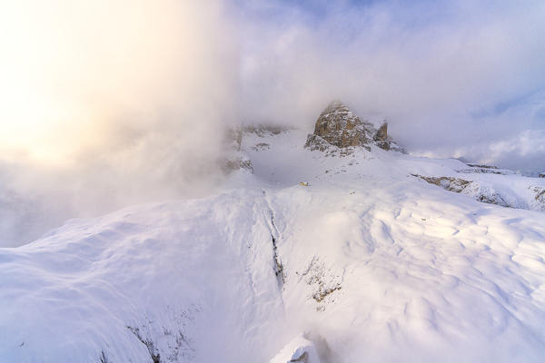 Mist over Rifugio Cavazza hut and Pisciadu in winter, aerial view, Gardena Pass, Dolomites, Trentino-Alto Adige, Italy