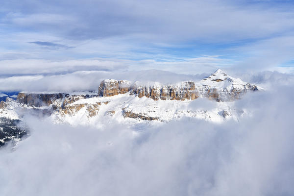 Aerial view of snow capped Sass Pordoi and Piz Boe emerging from clouds, Sella Group, Dolomites, Trentino-Alto Adige, Italy