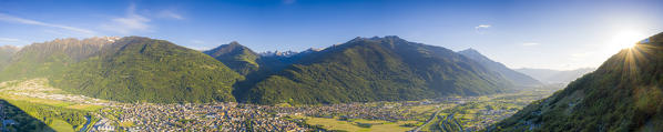 Orobie Alps and town of Morbegno lit by sunset in summer, aerial view, Valtellina, Sondrio province, Lombardy, Italy