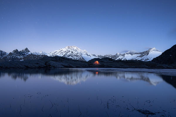 Snow capped Monte Disgrazia seen from a tent at dusk, Alpe Fora, Valmalenco, Sondrio province, Valtellina, Lombardy, Italy