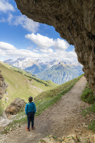 Rear view of little boy admiring Val di Fassa from the trail around the Sassolungo group, Dolomites, Trentino-Alto Adige, Italy