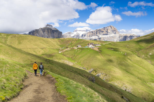 Rear view of hikers walking on path to Passo Sella and Rifugio Friedrich August, Dolomites, Trentino-Alto Adige, Italy