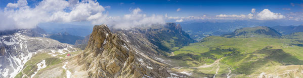 Aerial panoramic of Alpe di Tires hut at feet of Denti di Terrarossa and Alpe di Siusi/Seiser Alm, Dolomites, South Tyrol, Italy