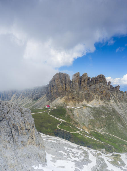 Panoramic of clouds on Denti di Terrarossa (Rosszahne) and Alpe di Tires hut, aerial view, Dolomites, Trentino Alto Adige, Italy