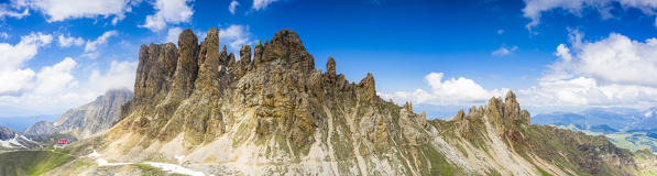 Panoramic of majestic Denti di Terrarossa mountains above Alpe di Tires hut, aerial view, Dolomites, Trentino Alto Adige, Italy