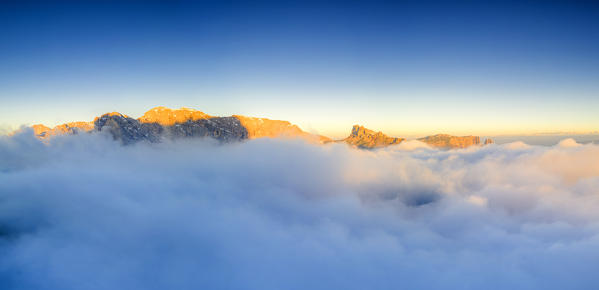 Cime di Terrarossa, Catinaccio d'Antermoia, Molignon and Sciliar  emerging from clouds at dawn,  Dolomites, South Tyrol, Italy