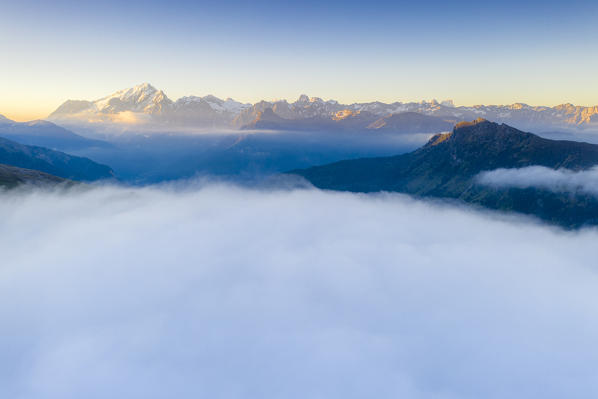 Aerial panoramic of Marmolada surrounded by mist at dawn, Dolomites, Trentino, Italy