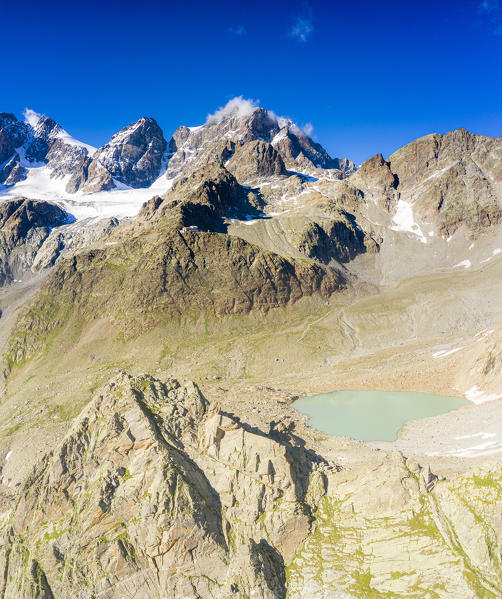 Clear summer sky over peaks of Bernina Group and Rifugio Marinelli hut, aerial view, Valmalenco, Valtellina, Lombardy, Italy