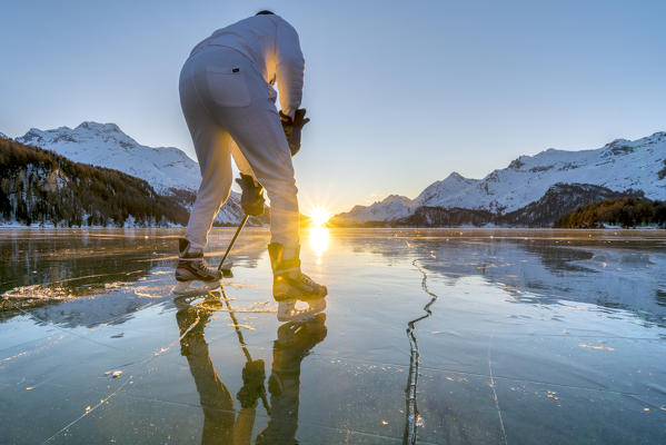 Rear view of ice hockey player on frozen Lake Sils at sunset, canton of Graubunden, Engadine, Switzerland (MR)