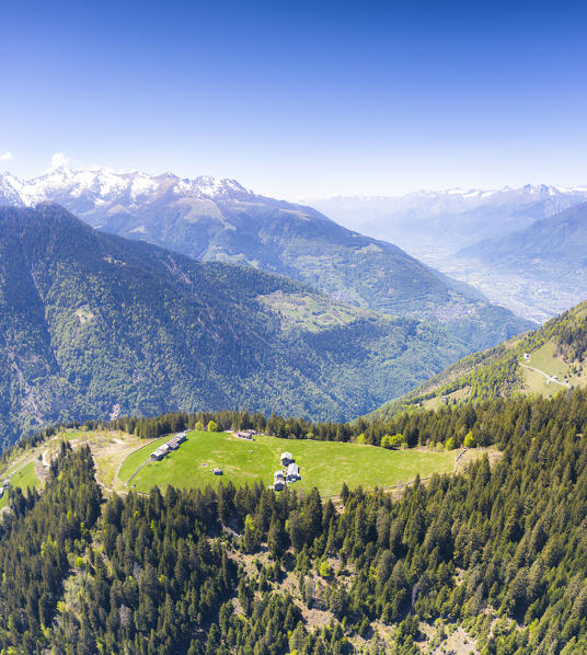 Aerial panoramic of woods and mountains surrounding the  alpine huts of Bema, Orobie Alps, Valgerola, Valtellina, Lombardy, Italy