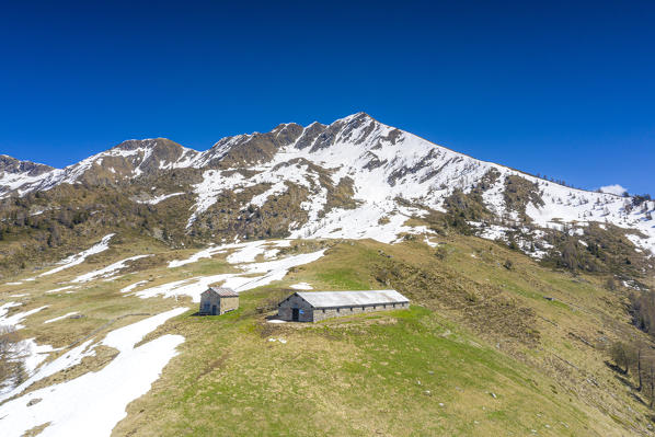 Clear summer sky over Legui bivouac and mountains partially snowy, Albaredo Valley, Orobie Alps, Valtellina, Lombardy, Italy