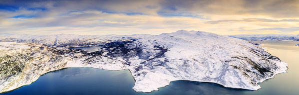 Aerial view of snow capped mountains and coastline along Altafjord during a winter sunset, Troms og Finnmark, Northern Norway