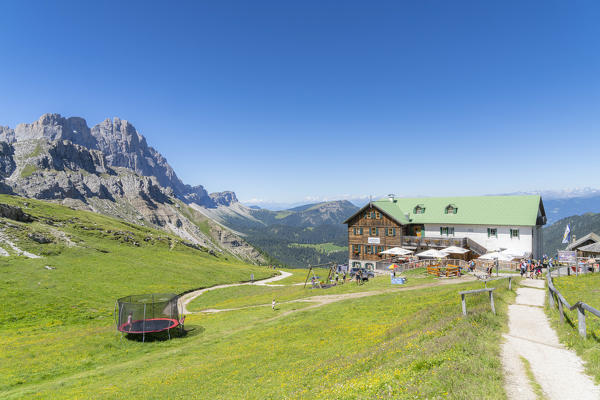 People enjoying summer at Rifugio Genova hut with Col di Poma and Odle on background, Val di Funes, South Tyrol, Dolomites, Italy