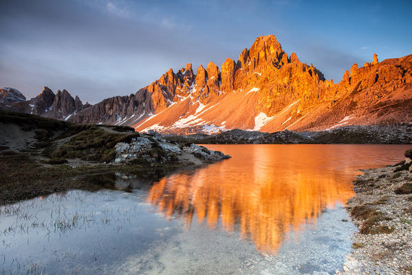 Dawn on the calcareous peaks of Mount Paterno reflected in the still water of Lakes of Piani. Locatelli refuge, Sesto of pusteria, Trentino Alto-Adige, Italy. Europe