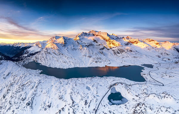 Panoramic aerial view of steep mountain road crossing the snowcapped mountains at Bernina pass, Graubunden, Engadin, Switzerland