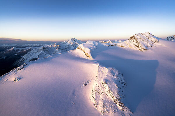 Pink sunrise on snowcapped Monte Disgrazia, Sassa Entova, Pizzo Malenco and Scerscen glacier, Valmalenco, Lombardy, Italy