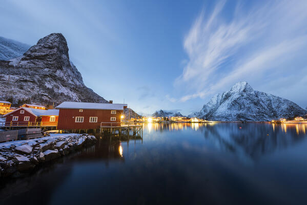 Winter dusk over snowcapped mountains and fishing village of Reine, Nordland county, Lofoten Islands, Norway