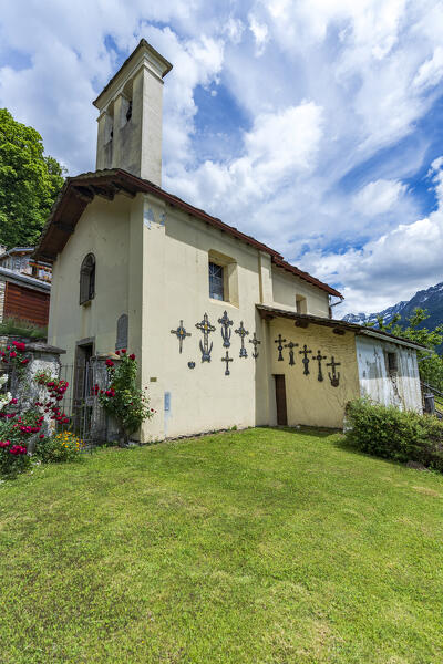 Summer sky over the old alpine church surrounded by green meadows, Crana, Piuro, Valchiavenna, Valtellina, Lombardy, Italy