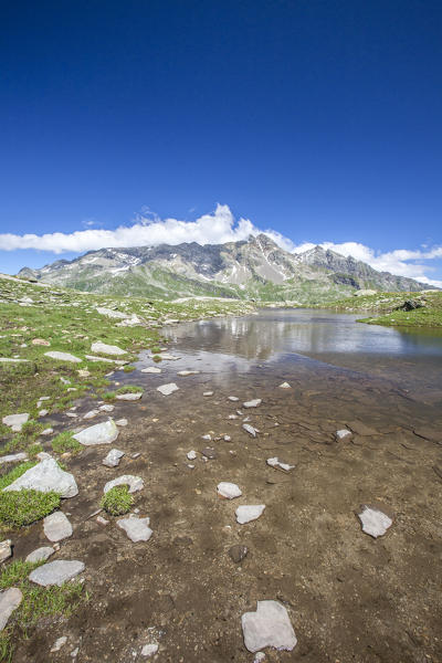 Shallow waters of Lake Bianco to Pian dei Cavalli. High Spluga Valley. Valtellina. Lombardy. Italy. Europe