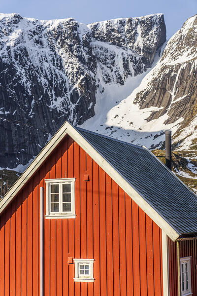 Red wood facade of traditional Rorbu house in the snow, Reine, Nordland county, Lofoten Islands, Norway