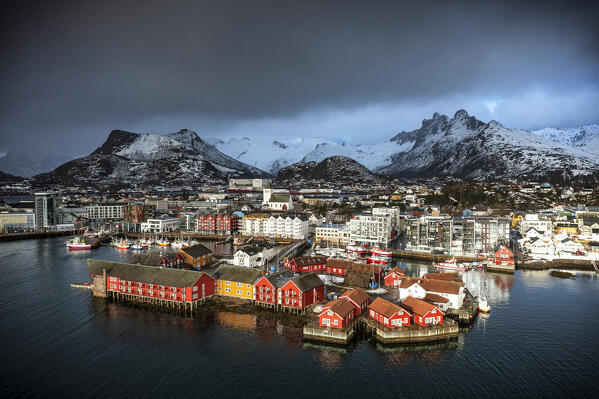 Storm clouds in the foggy sky over the snowcapped mountains surrounding Svolvaer, aerial view, Lofoten Islands, Norway