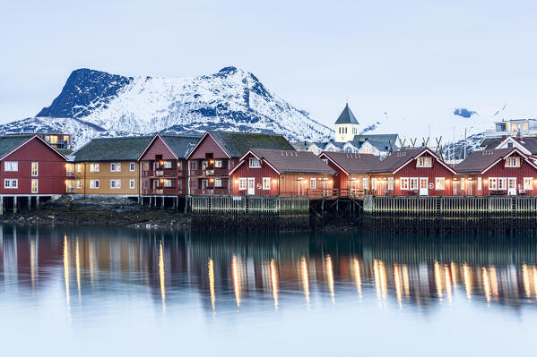 Illuminated Rorbu houses overlooking the cold arctic sea, Svolvaer, Nordland county, Lofoten Islands, Norway