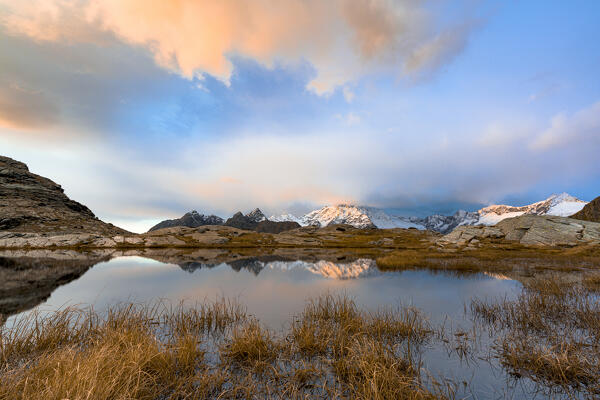 Monte Disgrazia and pristine lake sourrended by autumn colors, Alpe Fora, Valmalenco, Valtellina, Lombardy, Italy