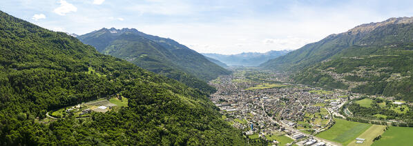 Aerial panoramic view of Morbegno town surrounded by woods, Valtellina, Sondrio province, Lombardy, Italy