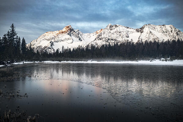 Sunrise over the frozen lake Entova and snowy peaks in winter, Valmalenco, Valtellina, Lombardy, Italy