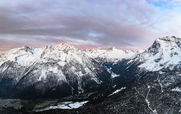 Aerial panoramic view of snowcapped Monte Disgrazia and Chiareggio at dawn, Valmalenco, Valtellina, Lombardy, Italy