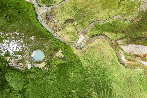 Aerial view of a river flowing nearby Pozza Blu pond in summer, Macolini, Madesimo, Valle Spluga, Valtellina, Lombardy, Italy