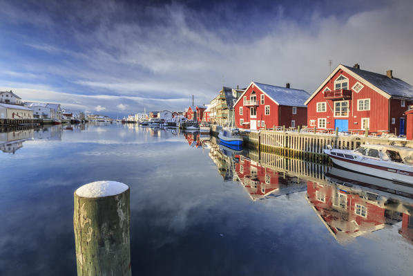 Red houses reflected in the canal of Henningsvaer. Lofoten Islands. Norway. Europe