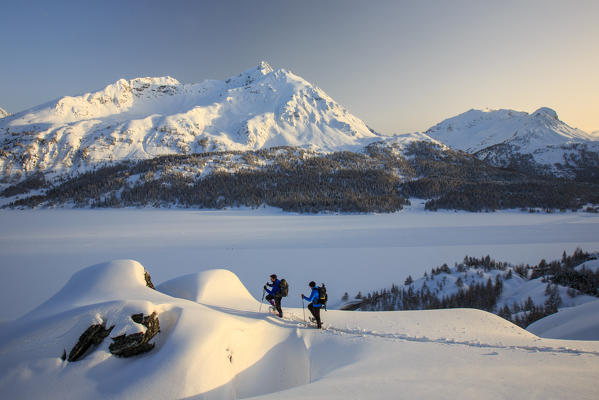 Snowshoe hikers reach a lookout on the Piz de la Margna. Maloja Pass. Engadine. Switzerland. Europe