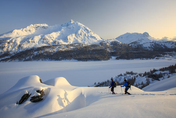 Snowshoe hikers reach a lookout on the Piz de la Margna. Maloja Pass. Engadine. Switzerland. Europe