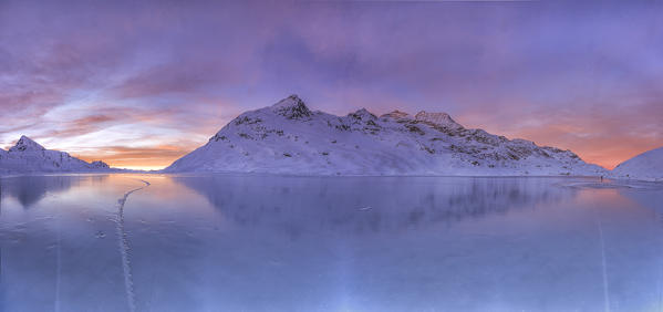 Overview from the frozen surface of Lake Bianco at the Bernina Pass at sunrise. Canton of Graubunden. Engadine. Switzerland. Europe