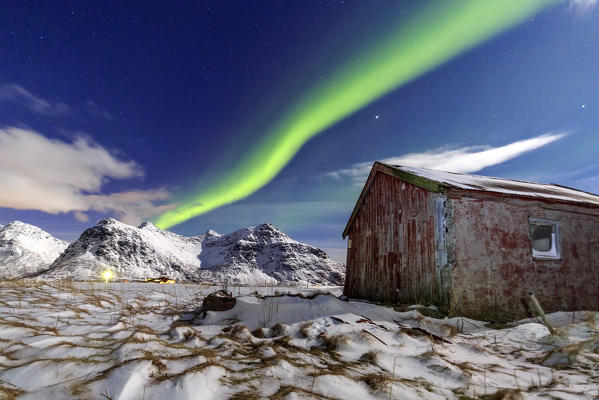 Northern Lights over an abandoned log cabin surrounded by snow and ice. Flakstad. Lofoten Islands Northern Norway Europe