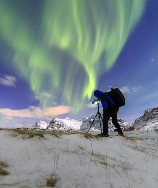 Photographer waits for the perfect light to take a picture of Northern Lights. Skagsanden Lofoten Islands Northern Norway Europe