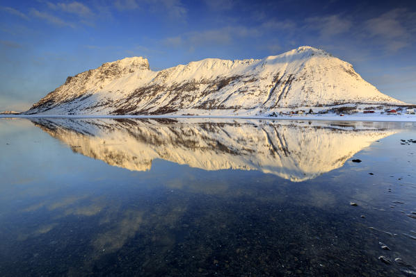 The snow capped mountains reflected in Steiropollen lake at sunrise. Lofoten Islands. Norway Europe