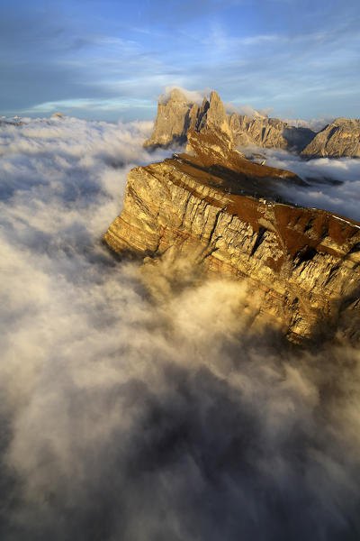 Aerial view from Seceda of Odle surrounded by clouds at sunset. Dolomites Funes Valley Trentino Alto Adige South Tyrol Italy Europe