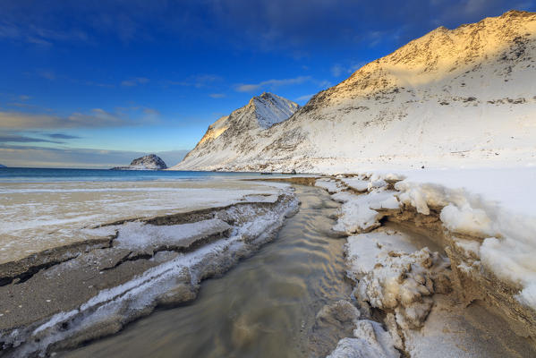 The golden sunrise illuminates the snowy peaks. Haukland Lofoten Islands Norway Europe