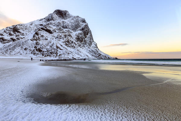 Dawn illuminates the partially snow covered beach of Uttakleiv. Lofoten Islands Norway Europe