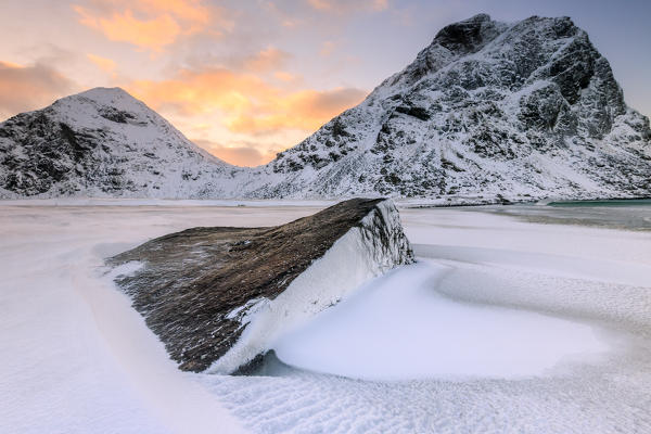 Dawn illuminates the rocks shaped by wind surrounded by fresh snow. Uttakleiv Lofoten Islands Norway Europe