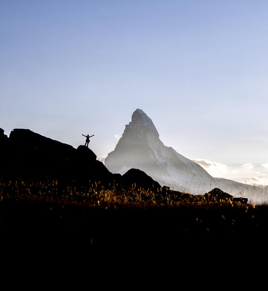 Hiker rejoices observing the Matterhorn from a panoramic location. Zermatt Canton of Valais Pennine Alps Switzerland Europe