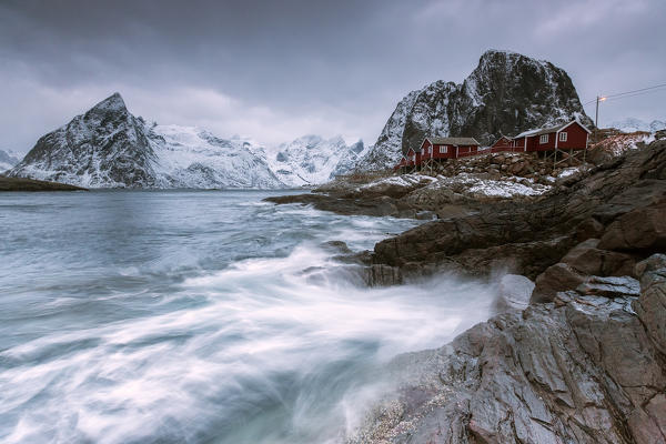 Cloudy sky on the typical red houses and the rough sea. Hamnøy. Lofoten Islands Northern Norway Europe