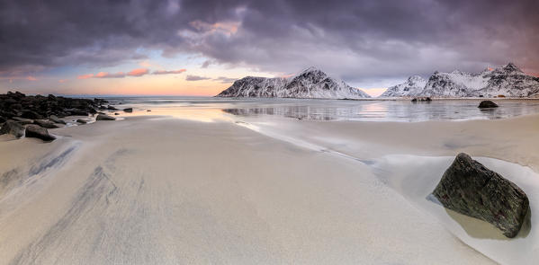 Panoramic view of the sandy beach of Skagsanden under a cloudy pink sky. Lofoten Islands. Northern Norway. Europe