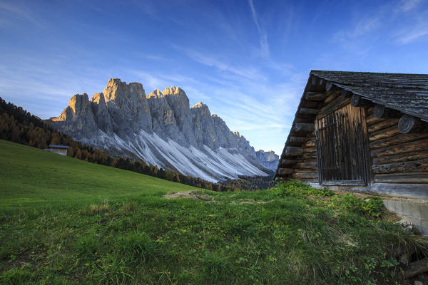 The early morning light illuminates Malga Zannes and the Odle in background. Funes Valley South Tyrol Dolomites Italy Europe