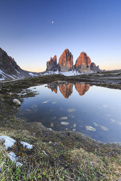 Dawn illuminates the Three Peaks of Lavaredo reflected in the lake. Sesto Dolomites Trentino Alto Adige Italy Europe