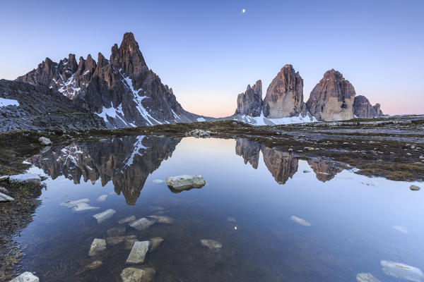 Dawn illuminates the Three Peaks and Mount Paterno reflected in the lake. Sesto Dolomites Trentino Alto Adige Italy Europe