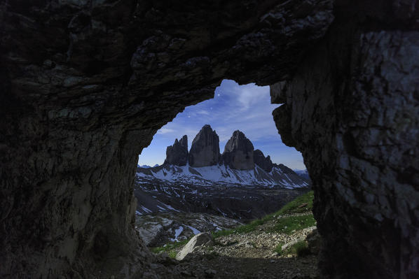 The Three Peaks of Lavaredo seen from a cave at night. Sesto Dolomites Trentino Alto Adige Italy Europe