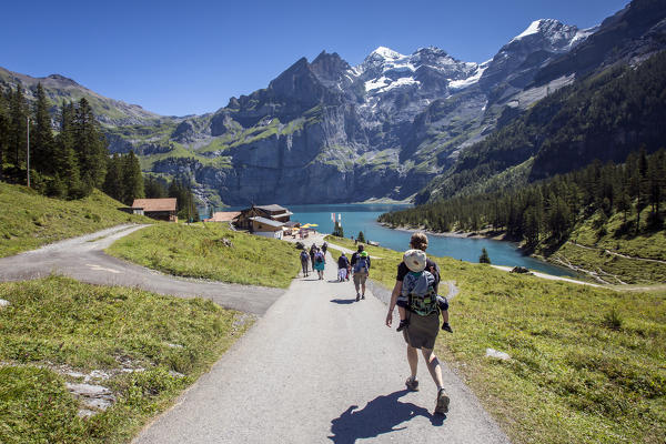 Hikers around Lake  Oeschinensee Bernese Oberland Kandersteg Canton of Bern Switzerland Europe